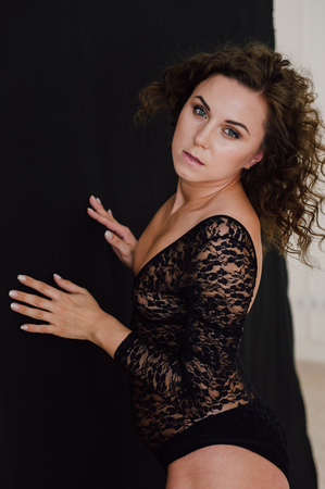 Sexy and beautiful woman wearing black lace body lingerie with curly hairの写真素材