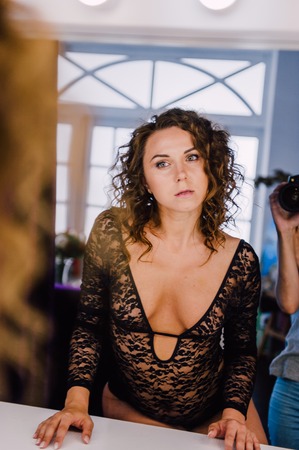 Sexy and beautiful woman wearing black lace body lingerie with curly hairの写真素材