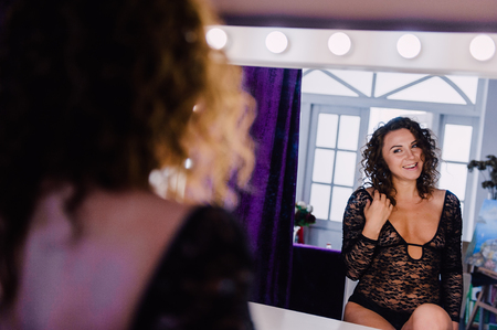 Sexy and beautiful woman wearing black lace body lingerie with curly hairの写真素材