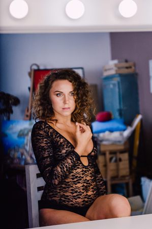 Sexy and beautiful woman wearing black lace body lingerie with curly hairの写真素材