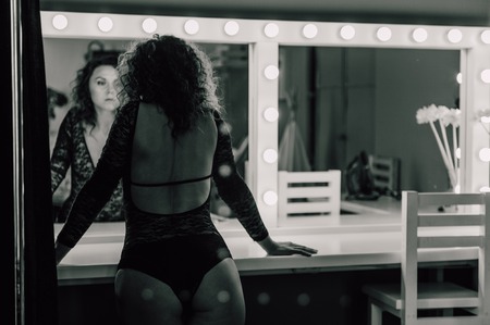 Sexy and beautiful woman wearing black lace body lingerie with curly hairの写真素材