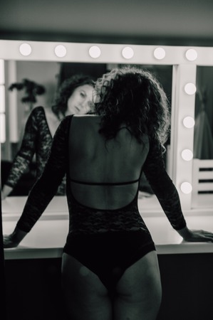 Sexy and beautiful woman wearing black lace body lingerie with curly hairの写真素材