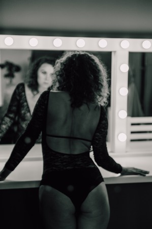 Sexy and beautiful woman wearing black lace body lingerie with curly hairの写真素材