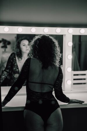 Sexy and beautiful woman wearing black lace body lingerie with curly hairの写真素材