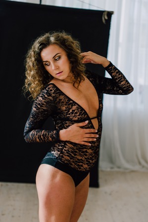 Sexy and beautiful woman wearing black lace body lingerie with curly hairの写真素材
