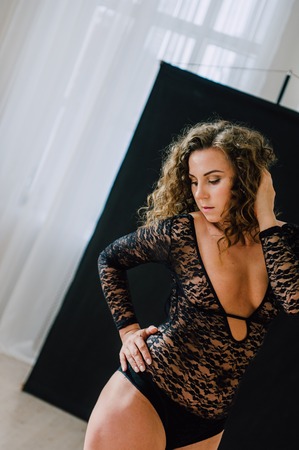 Sexy and beautiful woman wearing black lace body lingerie with curly hairの写真素材