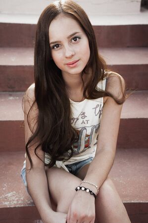 Girl having fun outdoor. Pretty girl sitting at school stadium. Rest from study. Outdoors, Lifestyleの写真素材