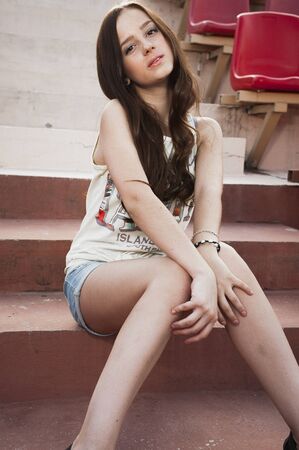 Girl having fun outdoor. Pretty girl sitting at school stadium. Rest from study. Outdoors, Lifestyleの写真素材