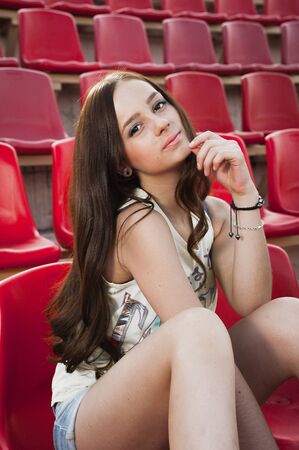 Girl having fun outdoor. Pretty girl sitting at school stadium. Rest from study. Outdoors, Lifestyleの写真素材
