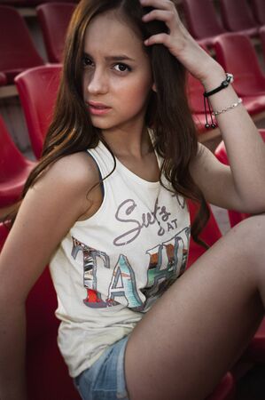 Girl having fun outdoor. Pretty girl sitting at school stadium. Rest from study. Outdoors, Lifestyleの写真素材