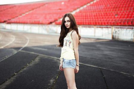 Girl having fun outdoor. Pretty girl sitting at school stadium. Rest from study. Outdoors, Lifestyleの写真素材