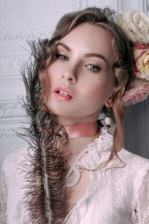 Beautiful young woman, hair decorated with flowers. Perfect makeup. Beauty fashion. Eyelashes. Studio retouched shot. Tender and sweet atmosphere, pastel colorsの写真素材