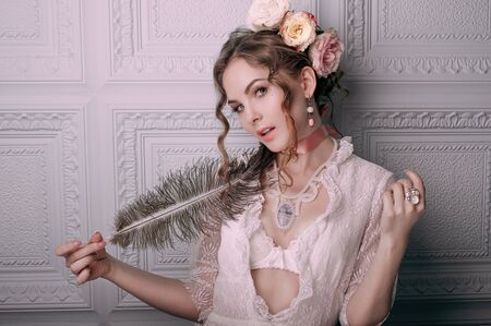 Beautiful young woman, hair decorated with flowers. Perfect makeup. Beauty fashion. Eyelashes. Studio retouched shot. Tender and sweet atmosphere, pastel colorsの写真素材