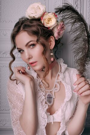 Beautiful young woman, hair decorated with flowers. Perfect makeup. Beauty fashion. Eyelashes. Studio retouched shot. Tender and sweet atmosphere, pastel colorsの写真素材