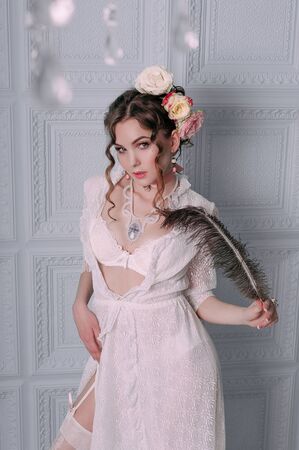 Beautiful young woman, hair decorated with flowers. Perfect makeup. Beauty fashion. Eyelashes. Studio retouched shot. Tender and sweet atmosphere, pastel colorsの写真素材