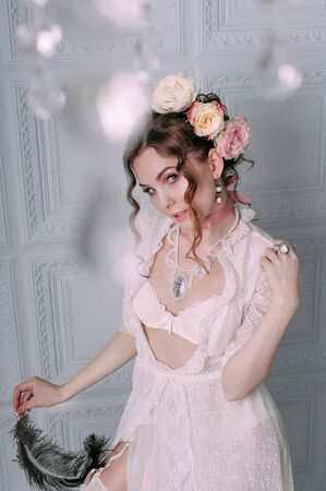 Beautiful young woman, hair decorated with flowers. Perfect makeup. Beauty fashion. Eyelashes. Studio retouched shot. Tender and sweet atmosphere, pastel colorsの写真素材