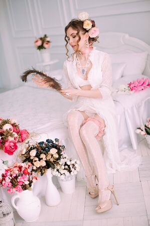 Beautiful young woman, hair decorated with flowers. Perfect makeup. Beauty fashion. Eyelashes. Studio retouched shot. Tender and sweet atmosphere, pastel colorsの写真素材