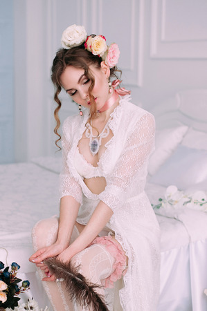Beautiful young woman, hair decorated with flowers. Perfect makeup. Beauty fashion. Eyelashes. Studio retouched shot. Tender and sweet atmosphere, pastel colorsの写真素材