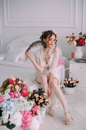 Beautiful young woman, hair decorated with flowers. Perfect makeup. Beauty fashion. Eyelashes. Studio retouched shot. Tender and sweet atmosphere, pastel colorsの写真素材