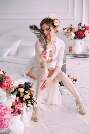 Beautiful young woman, hair decorated with flowers. Perfect makeup. Beauty fashion. Eyelashes. Studio retouched shot. Tender and sweet atmosphere, pastel colorsの写真素材