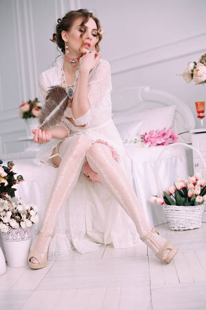 Beautiful young woman, hair decorated with flowers. Perfect makeup. Beauty fashion. Eyelashes. Studio retouched shot. Tender and sweet atmosphere, pastel colorsの写真素材
