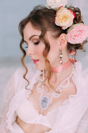 Beautiful young woman, hair decorated with flowers. Perfect makeup. Beauty fashion. Eyelashes. Studio retouched shot. Tender and sweet atmosphere, pastel colorsの写真素材