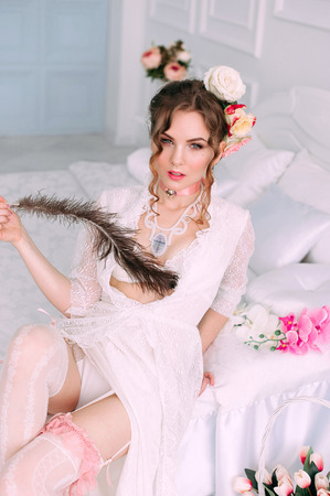 Beautiful young woman, hair decorated with flowers. Perfect makeup. Beauty fashion. Eyelashes. Studio retouched shot. Tender and sweet atmosphere, pastel colorsの写真素材