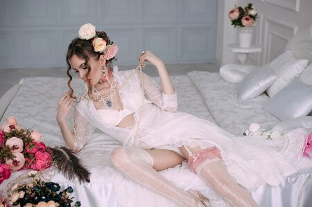Beautiful young woman, hair decorated with flowers. Perfect makeup. Beauty fashion. Eyelashes. Studio retouched shot. Tender and sweet atmosphere, pastel colorsの写真素材