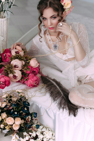 Beautiful young woman, hair decorated with flowers. Perfect makeup. Beauty fashion. Eyelashes. Studio retouched shot. Tender and sweet atmosphere, pastel colorsの写真素材