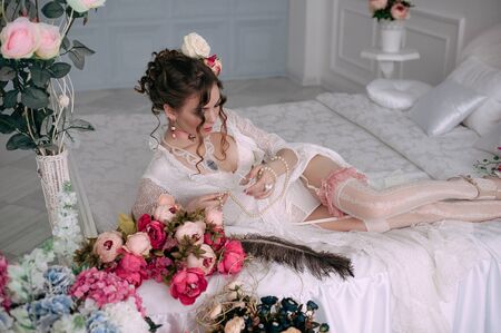 Beautiful young woman, hair decorated with flowers. Perfect makeup. Beauty fashion. Eyelashes. Studio retouched shot. Tender and sweet atmosphere, pastel colorsの写真素材
