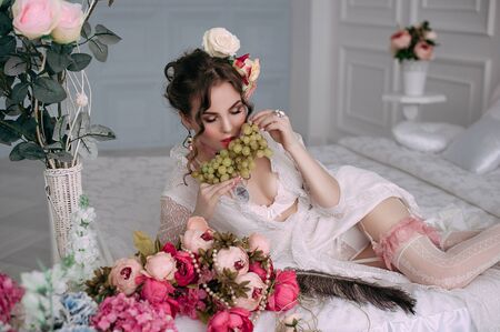 Beautiful young woman, hair decorated with flowers. Perfect makeup. Beauty fashion. Eyelashes. Studio retouched shot. Tender and sweet atmosphere, pastel colorsの写真素材