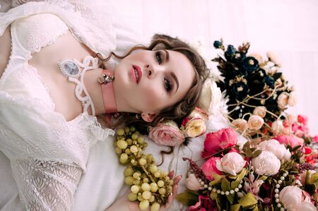 Beautiful young woman, hair decorated with flowers. Perfect makeup. Beauty fashion. Eyelashes. Studio retouched shot. Tender and sweet atmosphere, pastel colorsの写真素材
