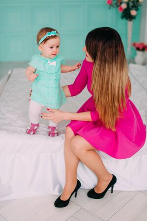 Mother and baby closeup portrait, happy faces, european family picture, adorable small girl, mom and kid having fun indoor, parents joy, holding little child, healthy toddler and mommy, happiness conceptの写真素材