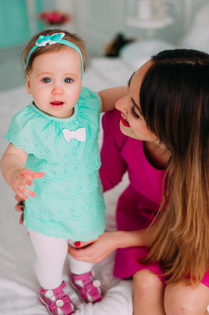 Mother and baby closeup portrait, happy faces, european family picture, adorable small girl, mom and kid having fun indoor, parents joy, holding little child, healthy toddler and mommy, happiness conceptの写真素材