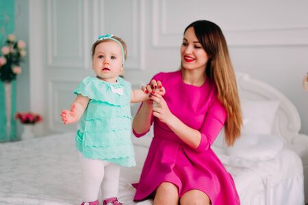 Mother and baby closeup portrait, happy faces, european family picture, adorable small girl, mom and kid having fun indoor, parents joy, holding little child, healthy toddler and mommy, happiness conceptの写真素材