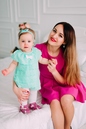 Mother and baby closeup portrait, happy faces, european family picture, adorable small girl, mom and kid having fun indoor, parents joy, holding little child, healthy toddler and mommy, happiness conceptの写真素材