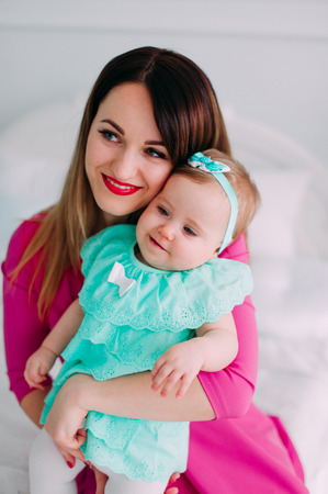 Mother and baby closeup portrait, happy faces, european family picture, adorable small girl, mom and kid having fun indoor, parents joy, holding little child, healthy toddler and mommy, happiness conceptの写真素材