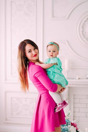 Mother and baby closeup portrait, happy faces, european family picture, adorable small girl, mom and kid having fun indoor, parents joy, holding little child, healthy toddler and mommy, happiness conceptの写真素材
