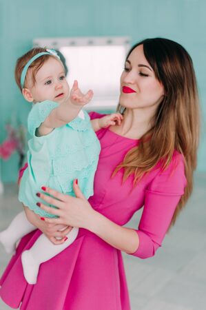 Mother and baby closeup portrait, happy faces, european family picture, adorable small girl, mom and kid having fun indoor, parents joy, holding little child, healthy toddler and mommy, happiness conceptの写真素材