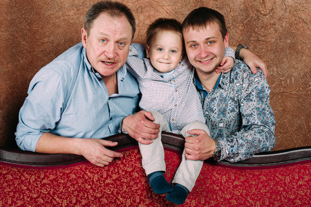 Three Generation Family Sitting On Sofa Together. Classic portraitの写真素材