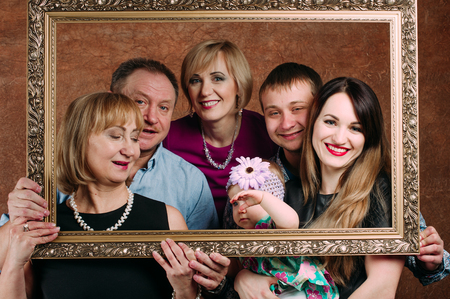 Three Generation Family Sitting On Sofa Together. Classic portrait in a frame