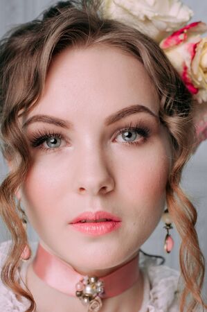 Beautiful young woman, hair decorated with flowers. Perfect makeup. Beauty fashion. Eyelashes. Studio retouched shot. Tender and sweet atmosphere, pastel colorsの写真素材