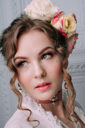 Beautiful young woman, hair decorated with flowers. Perfect makeup. Beauty fashion. Eyelashes. Studio retouched shot. Tender and sweet atmosphere, pastel colorsの写真素材