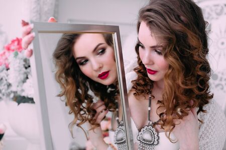 Beautiful young woman, hair decorated with flowers. Perfect makeup. Beauty fashion. Eyelashes. Studio retouched shot. Tender and sweet atmosphere, pastel colorsの写真素材