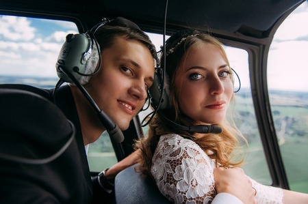 Happy beautiful newlyweds near the helicopterの写真素材