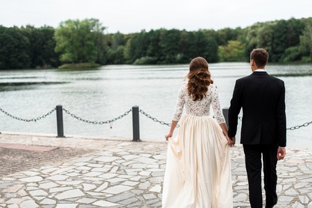 happy bride and groom at a park on their wedding dayの写真素材