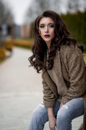 Spring in the country style. Full length portrait of young woman in white knitted sweater and furry...