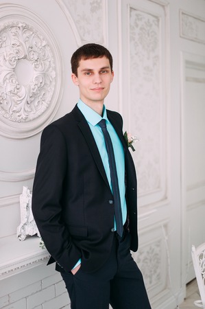 Full body portrait of young stylish businessman in tie and vest with hands on waistの写真素材
