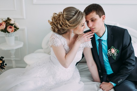 Happy couple. Wedding photo shoot in the white studio with wedding decor kisses, hugsの写真素材
