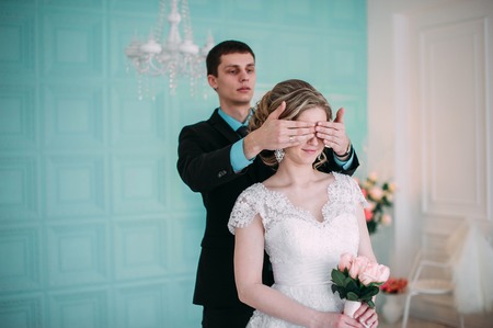 Happy couple. Wedding photo shoot in the white studio with wedding decor kisses, hugsの写真素材
